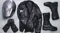 Ein Motorradhelm, Handschuhe, eine Lederjacke sowie Motorradstiefel von oben auf dem Boden