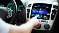 Ein Autofahrer bedient den Touchscreen eines Autos