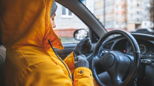 Frau lässt Motor im Auto warm laufen
