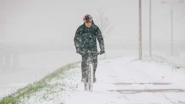 Fahrradfahrer fährt auf einem verschneiten Radweg