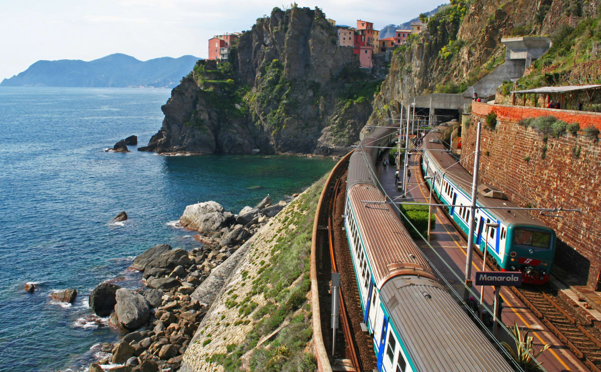 Ein Zug fährt in Cinque Terre in Italien direkt am Meer