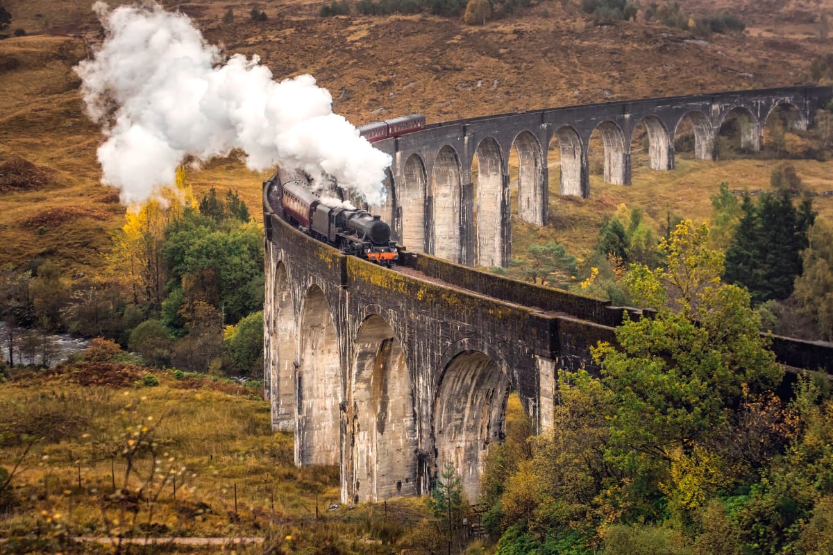 Ein Zug der West Highland Line fährt über das Glenfinnan Viadukt in Schottland