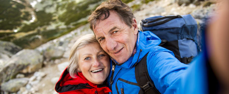 Älteres Paar beim Wandern macht Selfie - Unfallversicherung Senioren ADAC
