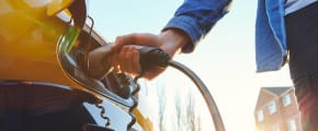 Mann lädt Elektroauto auf - Elektroauto Versicherung ADAC