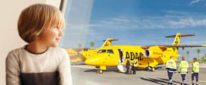 Kind sitzt am Fenster und schaut raus auf den ADAC Ambulanzjet