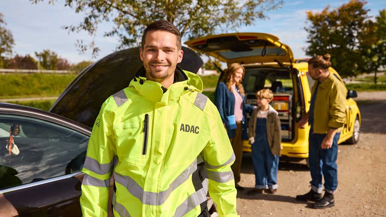 Ein ADAC Straßenwachtfahrer hilft einer Familie bei einer Autopanne