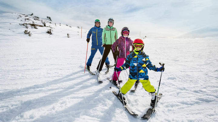 Familie steht auf Skipiste im Pflug - Unfallversicherung ADAC