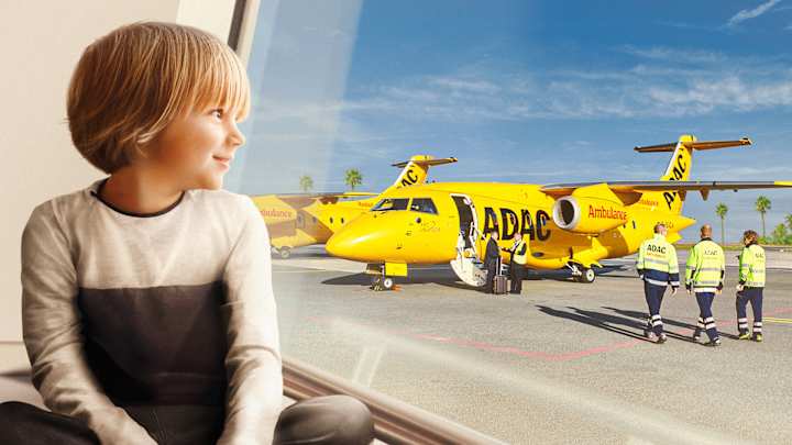 Kind sitzt am Fenster und schaut raus auf den ADAC Ambulanzjet