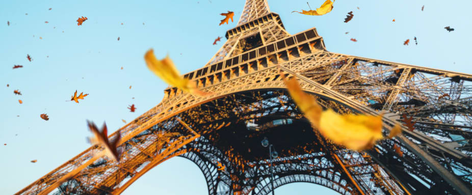 Herbstblätter fallen neben dem Pariser Eiffelturm