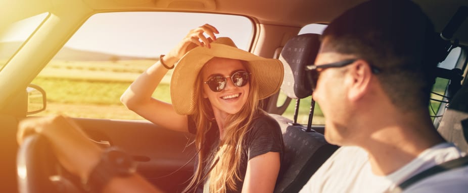 Paar im Auto lacht sich an - Zweitwagen versichern ADAC