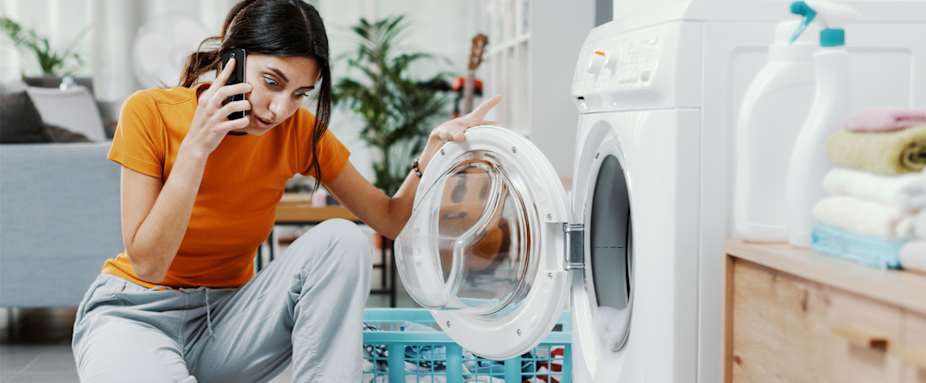 Frau sieht Schaum vor Waschmaschine