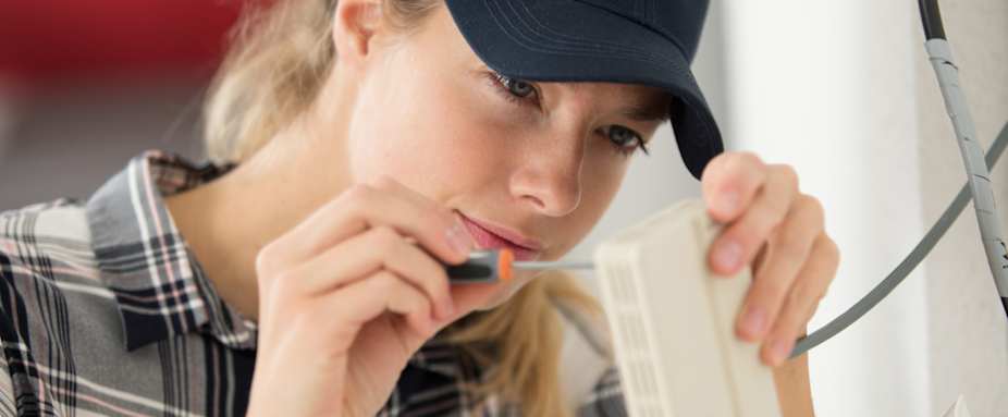 Elektroinstallateur schraubt an Elektronik - Elektro-Notdienst