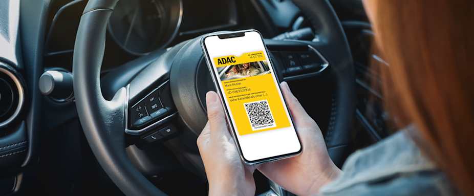 Frau sitzt im Auto und ruft AutoCard in Wallet auf Smartphone auf