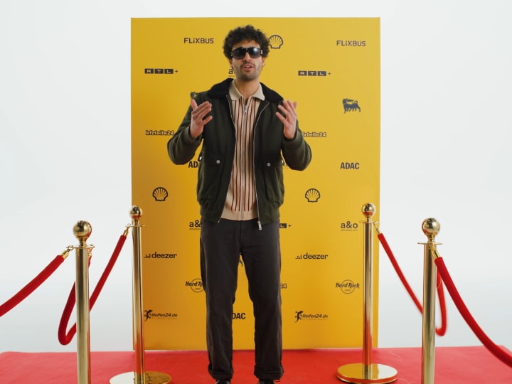 Junger Mann mit Sonnenbrille auf dem roten Teppich