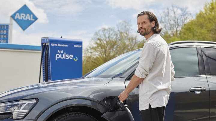 Ein Mann lädt E-Auto an ARAL Pulse Ladesäule