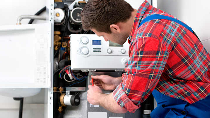 Heizungsinstallateur schraubt an Heizungsanlage - Heizungs-Notdienst