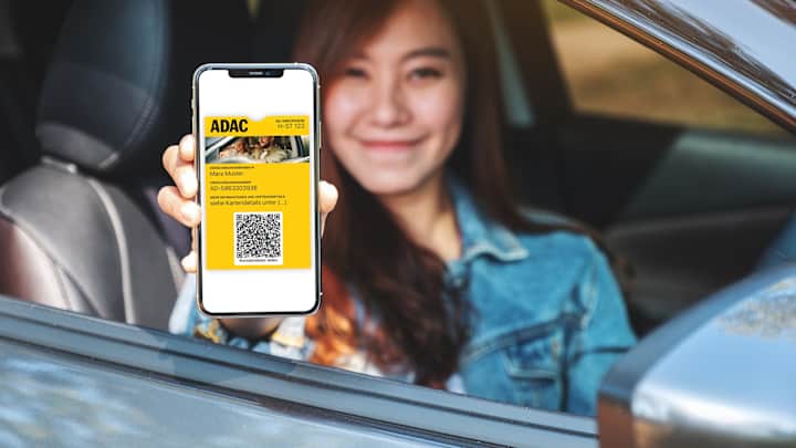 Frau sitzt im Auto und zeigt AutoCard in Wallet auf Smartphone