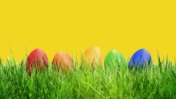 Bunte Eier im Gras vor gelbem Hintergrund - ADAC Unfallschutz gut aufgehoben