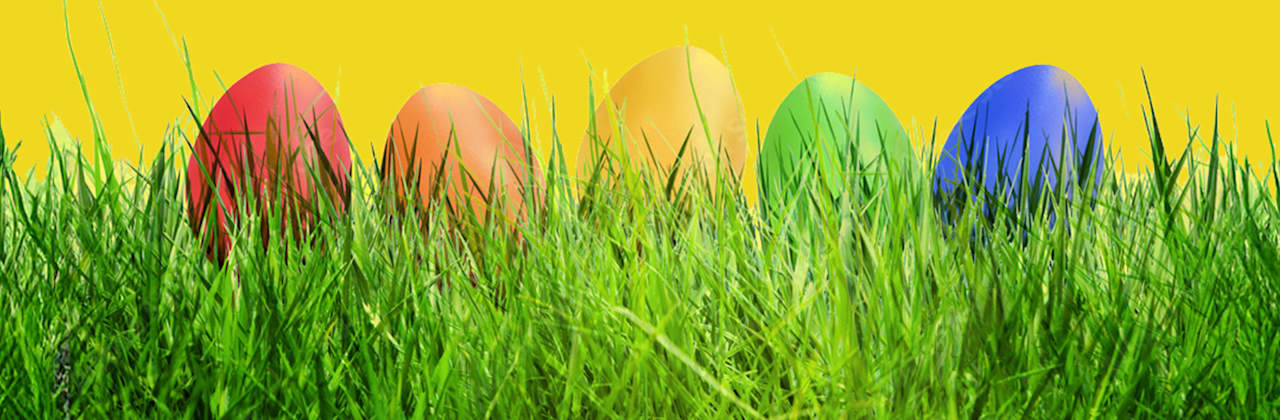 Bunte Eier im Gras vor gelbem Hintergrund - ADAC Unfallschutz gut aufgehoben