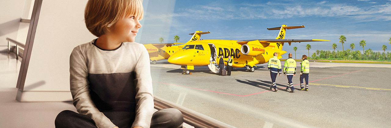 Junge sitzt am Flughafen, schaut aus dem Fenster