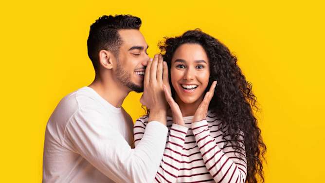 Mann flüstert Frau etwas zu - Versicherungen empfehlen ADAC