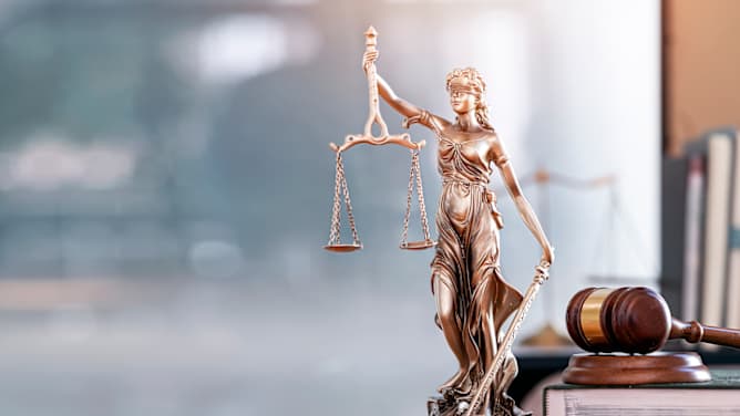 Eind Skulptur Justizia steht auf einem Schreibtisch