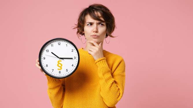 Frau zeigt Uhr mit Paragraphenzeichen und schaut fragend