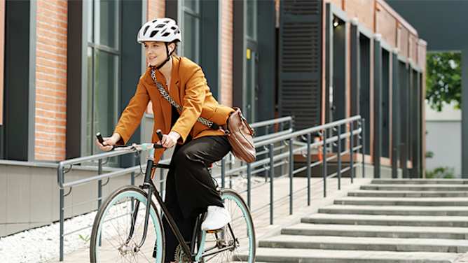 Fahrradversicherung: Frau mit Helm auf Citybike
