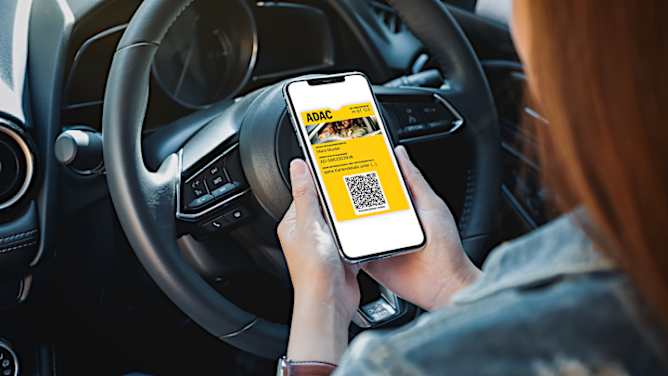 Frau sitzt im Auto und ruft AutoCard in Wallet auf Smartphone auf