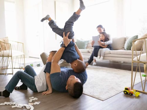 Familie spielt im Wohnzimmer - Unfallversicherung ADAC