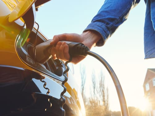 ADAC Elektroauto Versicherung - Mann lädt Elektroauto auf