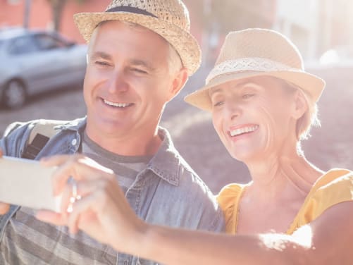 Ein älteres Pärchen macht im Urlaub ein Selfie auf der Straße
