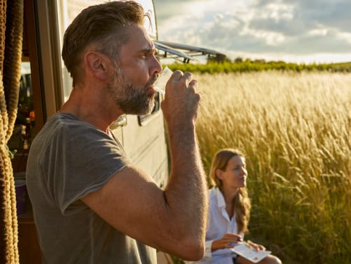 Mann und Frau mit dem Wohnwagen unterwegs - Kfz Versicherung für Camper ADAC
