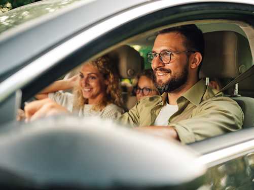 Familie fährt im Auto - Familien Kfz Versicherung ADAC
