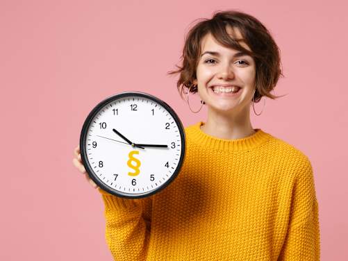 Frau zeigt Uhr mit Paragraphenzeichen und grinst