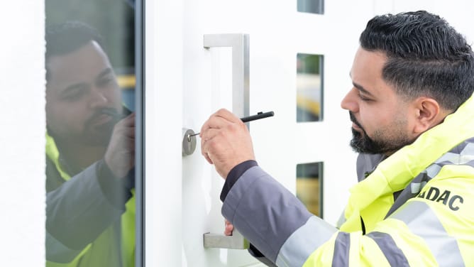 ADAC Schluesselnotdienst arbeitet konzentriert am Tuerschloss