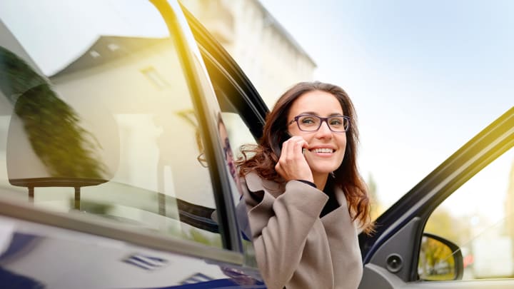 Frau sitzt im Auto und telefoniert - Verkehr Rechtsschutz ADAC