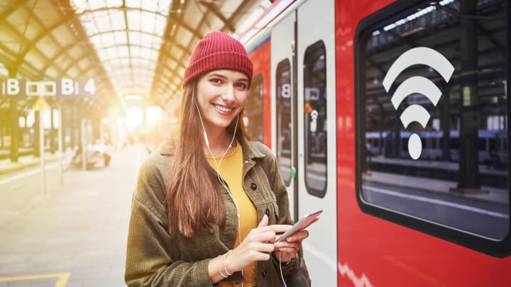 Frau mit Smartphone am Zug