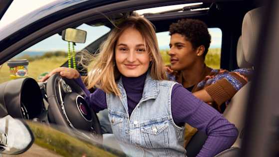Junge Frau im Auto, junger Mann als Beifahrer