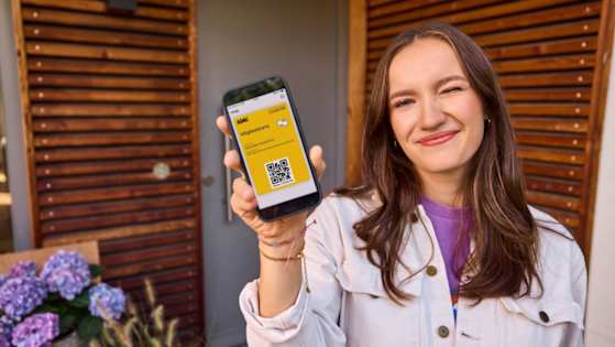 Junge Frau zeigt digitale ADAC Mitgliedskarte vor