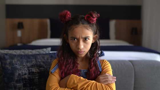 Mädchen sitzt beleidigt auf dem Sofa - rechtsschutzversicherung adac