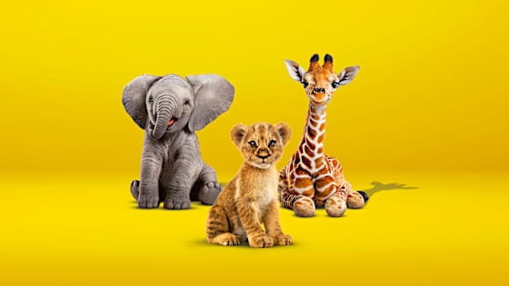 kleiner Elefant, kleiner Löwe und kleine Giraffe sitzen auf gelbem Boden - Tierfreunde ADAC Autoversicherung