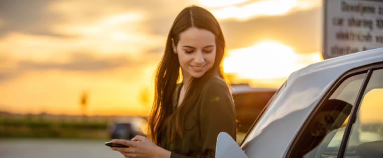 Frau lädt eine Elektroauto - Elektroauto-Versicherung