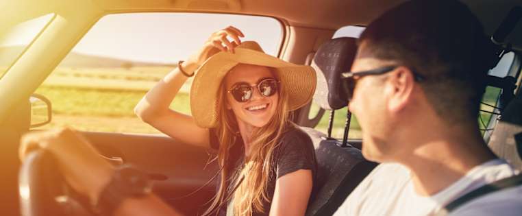 Paar im Auto lacht sich an - Zweitwagen versichern ADAC
