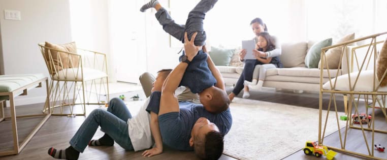 Familie spielt im Wohnzimmer - Unfallversicherung ADAC