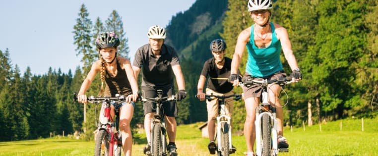 Familie beim Radfahren auf Weg - Unfallversicherung ADAC
