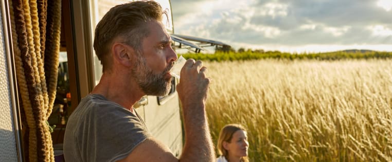 Mann und Frau mit dem Wohnwagen unterwegs - Kfz Versicherung für Camper ADAC