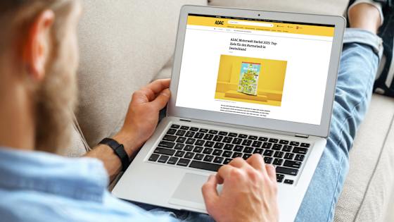 Ein Mann liest auf seinem Laptop das Motorwelt E-Paper