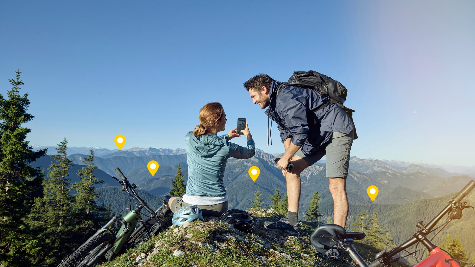 Mann und Frau nutzen Smartphone auf Berggipfel