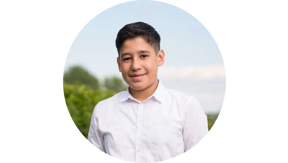 13-jähriger Junge lächelnd im Garten